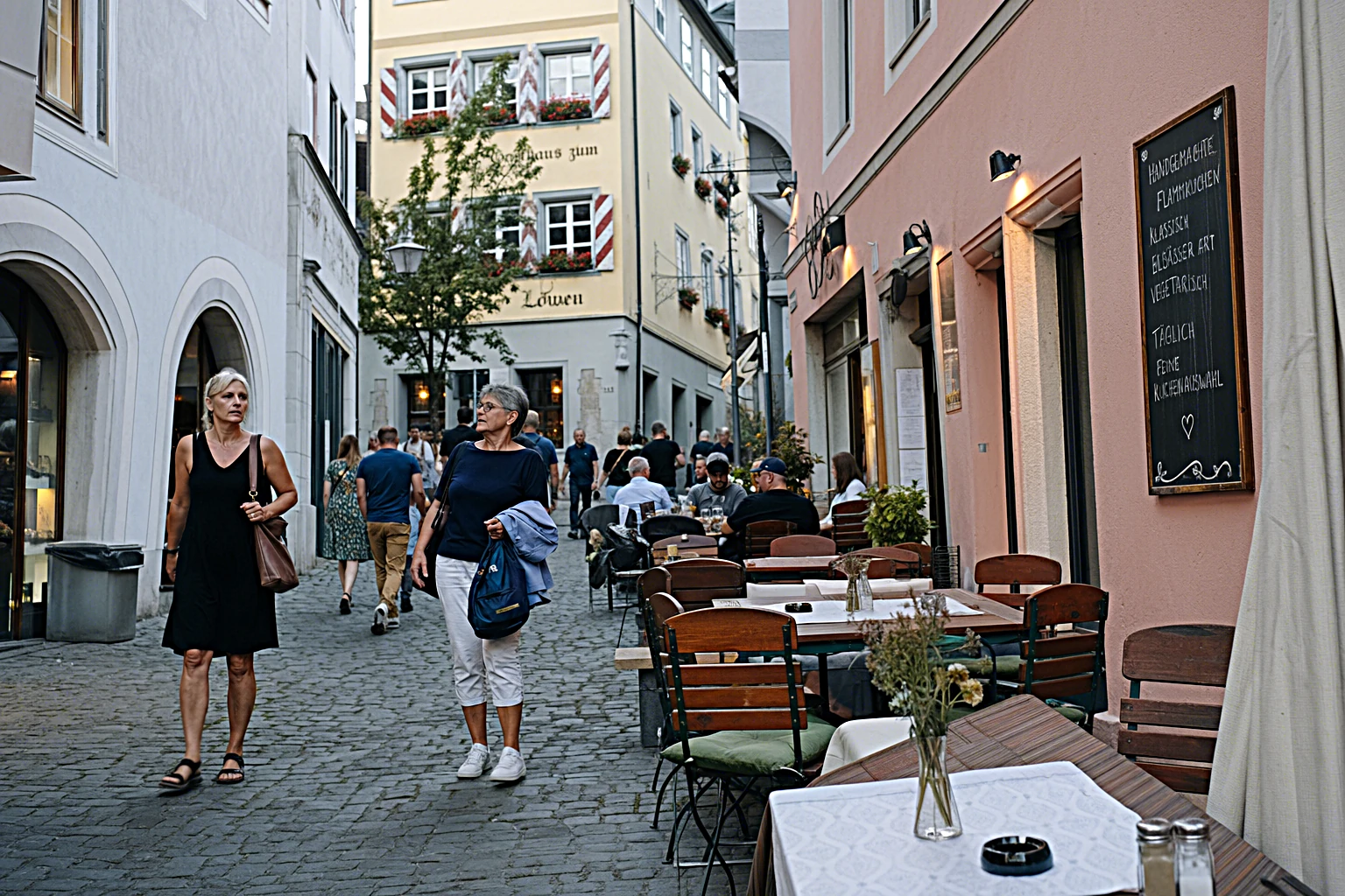 Altstadtgasse einer deutschen Stadt im sommerlichen Abendlicht mit Cafétischen